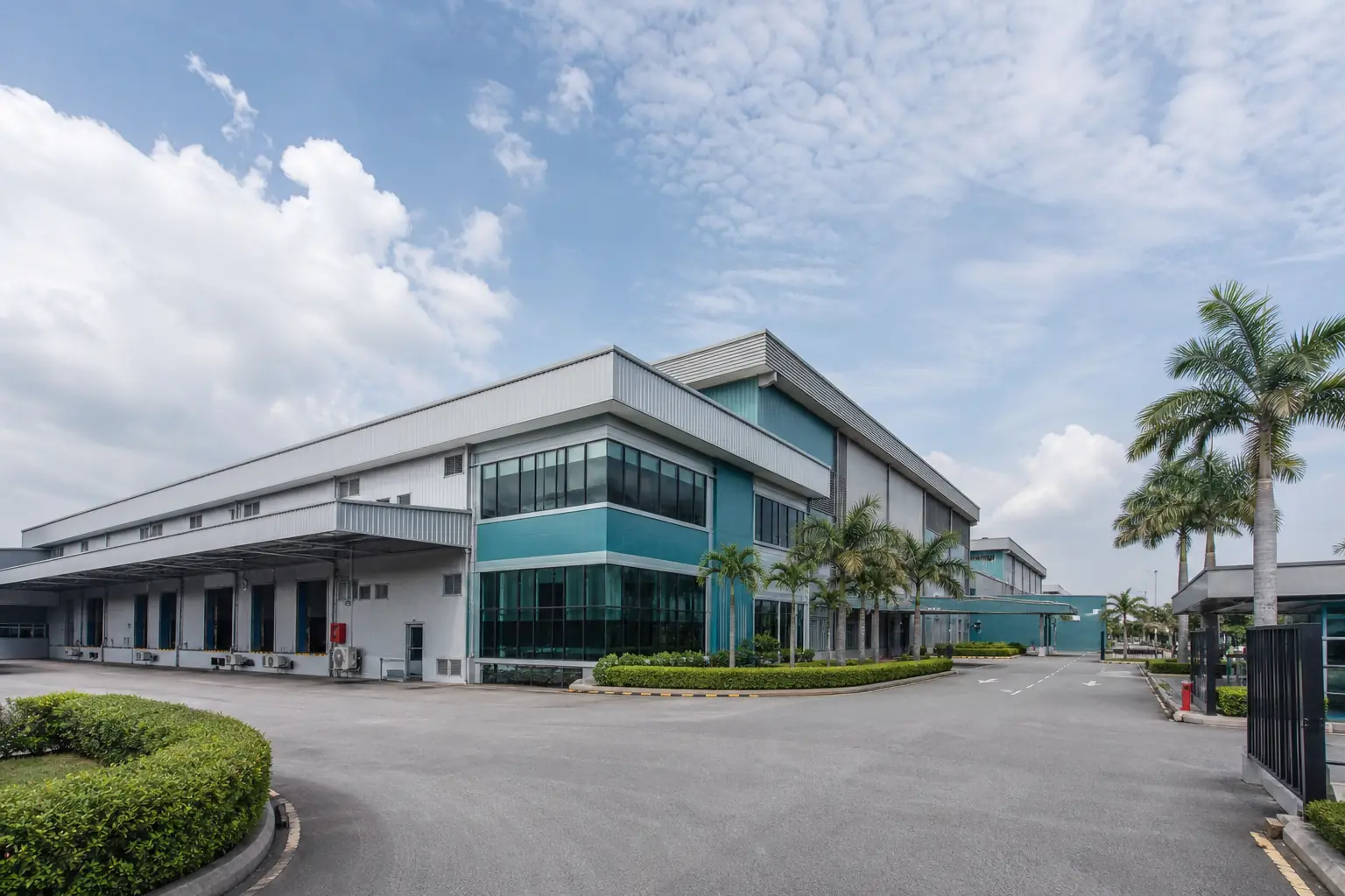 Industrial manufacturing campus exterior with factory buildings under a tropical sky